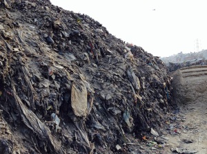 A 15 foot mountain of plastics and garbage lines the holy Bagmati River recently dredged as part of a road expansion project. Copyright Donatella Lorch
