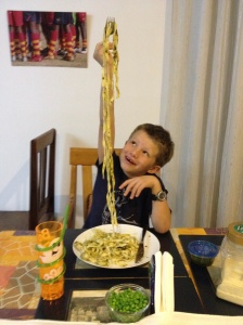 FaceTime is everywhere with us. Here John looks on as Lucas samples  pasta he helped make. © Donatella Lorch