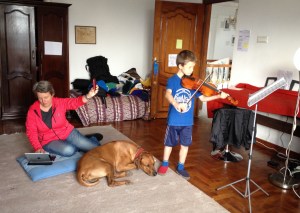 Lucas, in Nepal, practices violin on FaceTime, with his father in Dhaka, Bangladesh. © Donatella Lorch