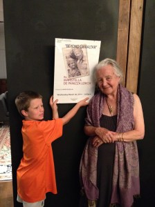 Mina with her grandson Lucas this summer holding up the poster for the launch of her most recent novel ©Donatella Lorch